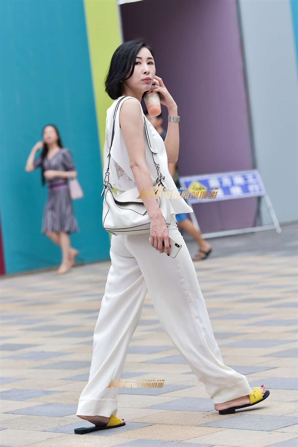 图片[1]-悠闲自在的白裤女-街拍流行馆